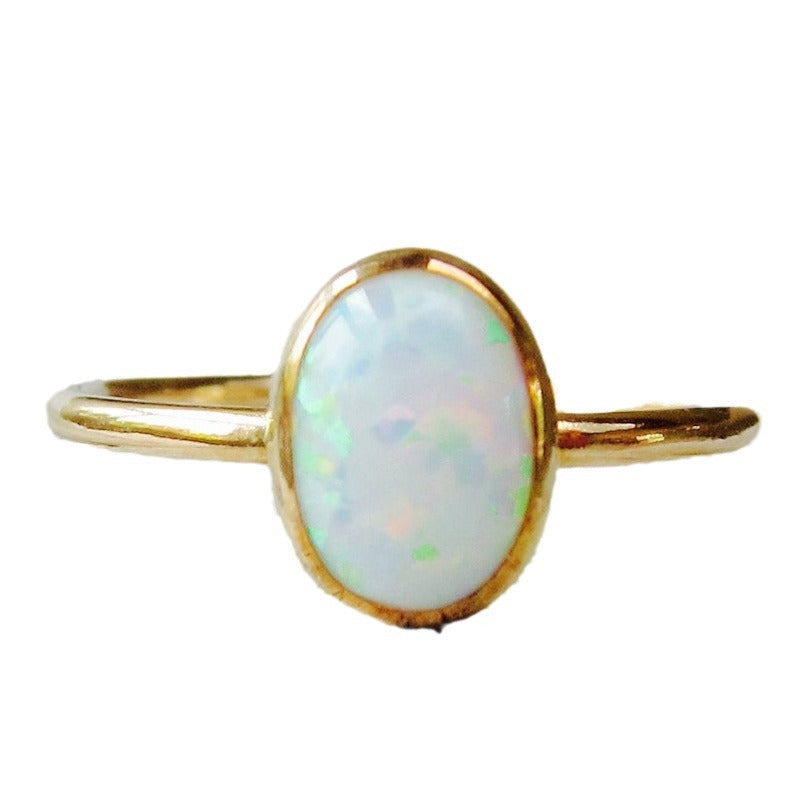 Gold-tone ring with white opal-look oval stone